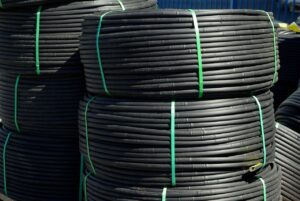 Sistema di irrigazione a goccia installato in un giardino, evidenziando piante verdi e fiori fioriti.