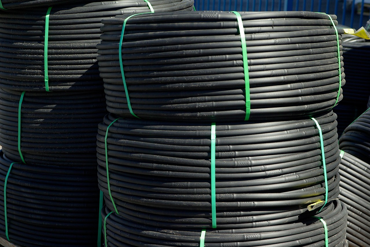Sistema di irrigazione a goccia installato in un giardino, evidenziando piante verdi e fiori fioriti.